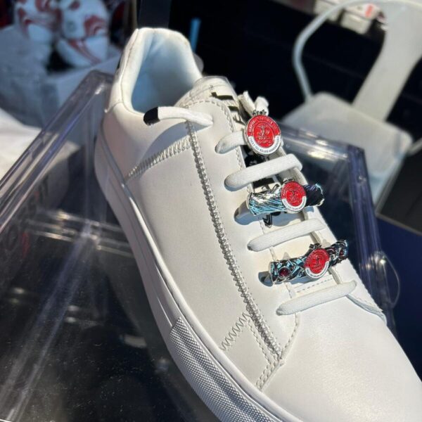 זוג תכשיטים לנעליים מכסף עם לוגו של קבוצת כדורגל הפועל תל אביב על נעל סניקרס לבנה